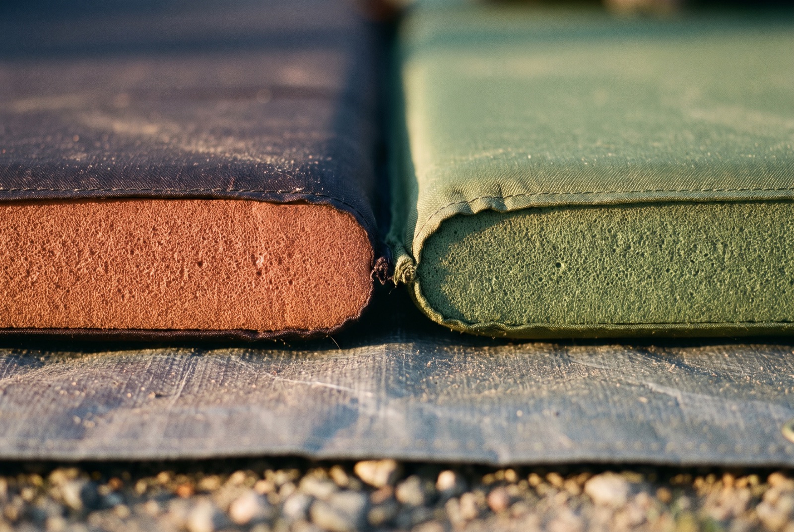 Two self-inflating mats pressed edge to edge on a groundsheet with no gap between them, seen in close-up from floor level